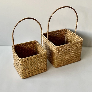 Detail of seagrass woven baskets set with arched handles for home storage or gifts