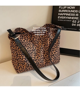 Close-up of leopard print shoulder bag with adjustable black glossy strap and gold buckle
