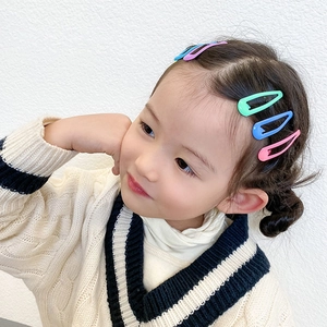 Close-up of vibrant pink, blue, and green metallic drop-style hair clips on child model