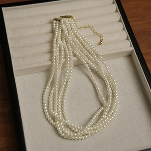 Elegante collana di perle multistrato con chiusura dorata in una scatola per gioielli nera