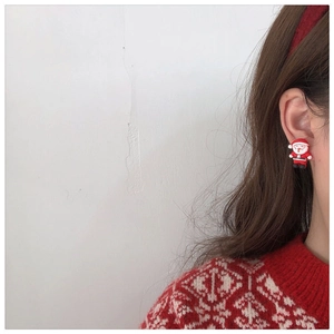 Close-up of a Santa Claus resin stud earring worn by a model for Christmas style
