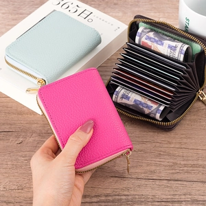 Close-up of litchi pattern card holders in mint, pink and brown on a desk