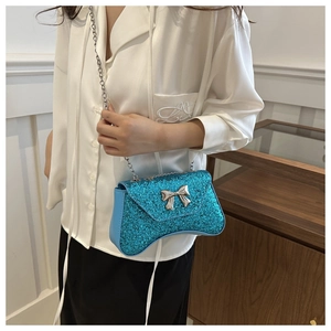 Close-up of blue sequin evening bag featuring a silver chain strap and metal bow clasp