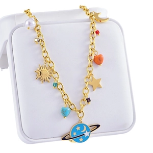 Golden necklace with blue planet, moon and heart pendants on a white jewelry box
