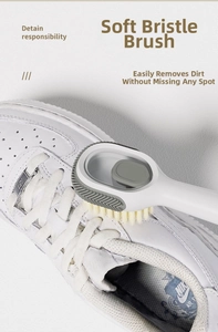 Detail of soft bristle shoe brush with side scraper cleaning white sneakers