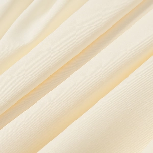 Dettaglio del morbido tessuto a maglia color crema che mostra la trama fine e la qualità