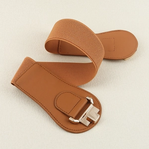 Detail view of a brown wide waist belt with metallic buckle and elastic stretch band