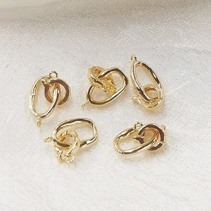 Macro shot of 5 pieces of gold S925 sterling silver DIY necklace clasps on white fabric