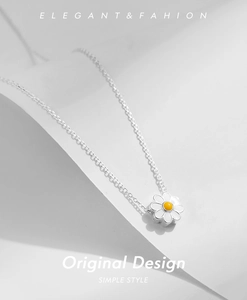 Detailed close-up of a white enamel daisy pendant on a polished S925 silver chain
