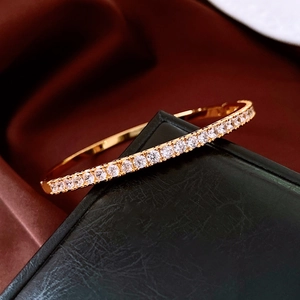 Detail of 24K gold plated bangle featuring a row of pave-set round white cubic zirconia stones