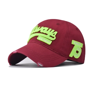 Detail of 3D neon green embroidery on vintage burgundy cotton baseball cap with distressed brim