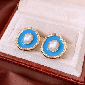 Vintage oval pearl earrings with sky blue enamel and gold trim in a luxury jewelry box