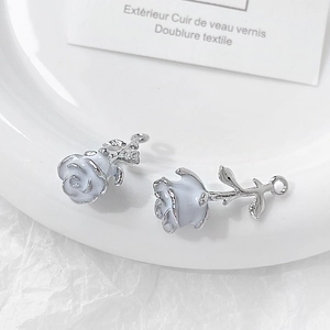 Detail of silver rose pendants with white enamel petals for jewelry making accessories