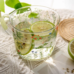 Macro shot of glass water cup with floral pattern and 100ml 200ml capacity scale