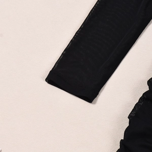 Détail des poignets en maille noire avec ourlet double et texture fine transparente
