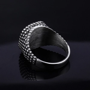 Polished silver stainless steel ring with textured surface on a sleek black background
