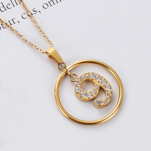Macro shot of gold stainless steel necklace featuring a crystal-encrusted number 9 pendant