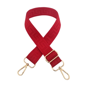 Macro detail of red 3.8cm adjustable bag strap with gold hooks and geometric texture