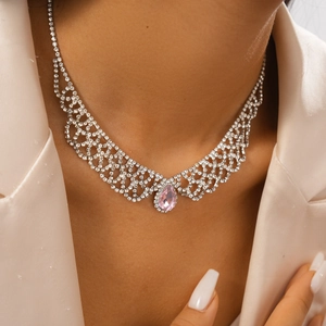Detail of silver mesh necklace featuring a pink pear-shaped stone and sparkling rhinestones