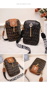 Detail of printed crossbody phone bag with metal crown buckle and tassel charm