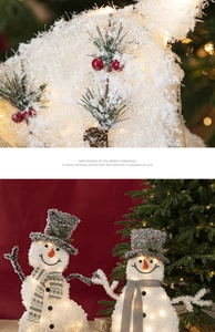 Nahaufnahme eines leuchtenden Weihnachts-Schneemanns mit Zapfen und Strickschal-Details