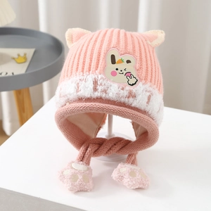 Close-up of pink knit earflap hat for kids with bunny patch and furry trim details