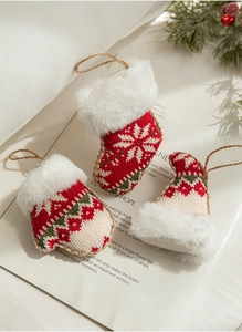 Macro detail of knit Christmas ornaments featuring festive gloves and stockings with pine