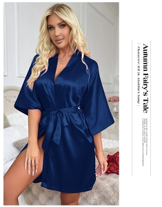 Detailed macro view of the luxurious navy blue satin fabric and tie belt of the robe