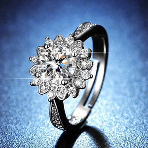 Close-up of a sunflower-shaped moissanite ring with side accent stones on a blue background