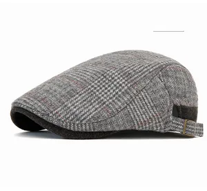 Close-up of light gray plaid wool beret with adjustable metal buckle detail