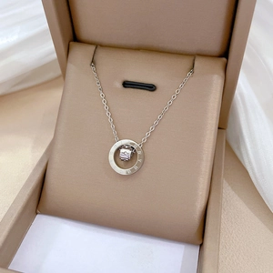 Detailed view of silver titanium steel rotating double ring pendant with roman numerals