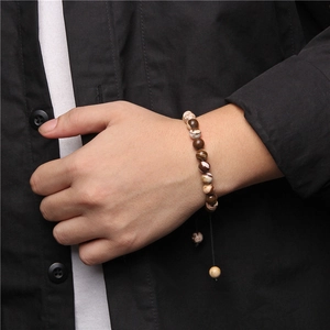 Detailed view of handmade woven tiger eye stone bracelet with adjustable cord and beads