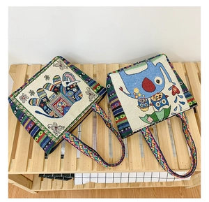 Detailed view of canvas tote bags featuring ethnic embroidery and woven bohemian straps