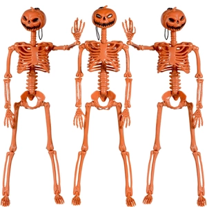 Detailed view of three orange pumpkin-headed skeleton props for Halloween decorations