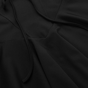 Detailaufnahme des V-Ausschnitts und der feinen Träger an einem eleganten schwarzen Kleid
