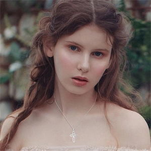 Elegant S925 sterling silver heart cross pendant necklace worn by a model in nature