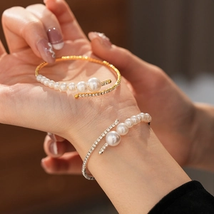 Close-up of elegant open cuff bracelet with pearls and pavé set cubic zirconia