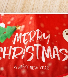 Close-up of red plush Christmas tree skirt with Merry Christmas text and festive prints