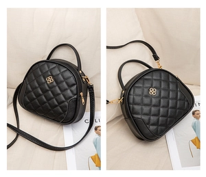 Detail view of black quilted crossbody bag with golden clover hardware and leather texture