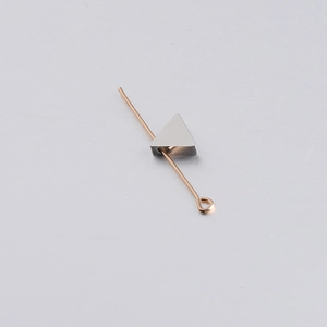 Detail view of silver triangle bead with golden eye pin for DIY jewelry making