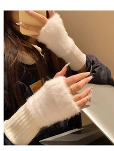 Detailed view of plush white faux fur fingerless gloves used for office laptop typing