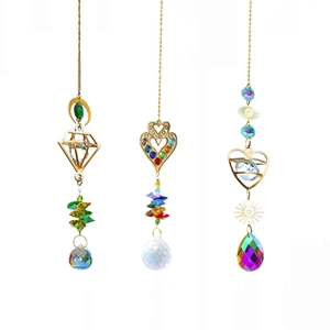 Three gold crystal suncatchers with heart and diamond frames on white background