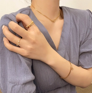 Close-up of elegant gold S925 sterling silver layered rings and jewelry on a model