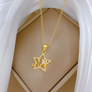 Macro detail of gold star pendant with Mama engraving and sparkling crystals