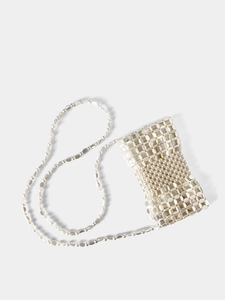 Detail of white beaded crossbody bag featuring woven texture and pearl strap accents