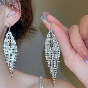 Macro detail of silver geometric tassel earrings featuring sparkling pavé crystals