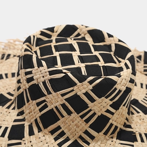 Close-up of the dual-tone woven straw hat top showing intricate black check patterns