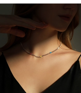 Detail of s925 silver choker necklace with colorful enamel heart pendants on model neck
