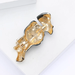 Détail de l'arrière de la broche masque en émail doré avec texture métal et fermoir