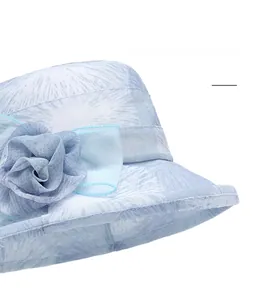 Detail of light blue mesh sun hat featuring a decorative fabric rose and breathable texture